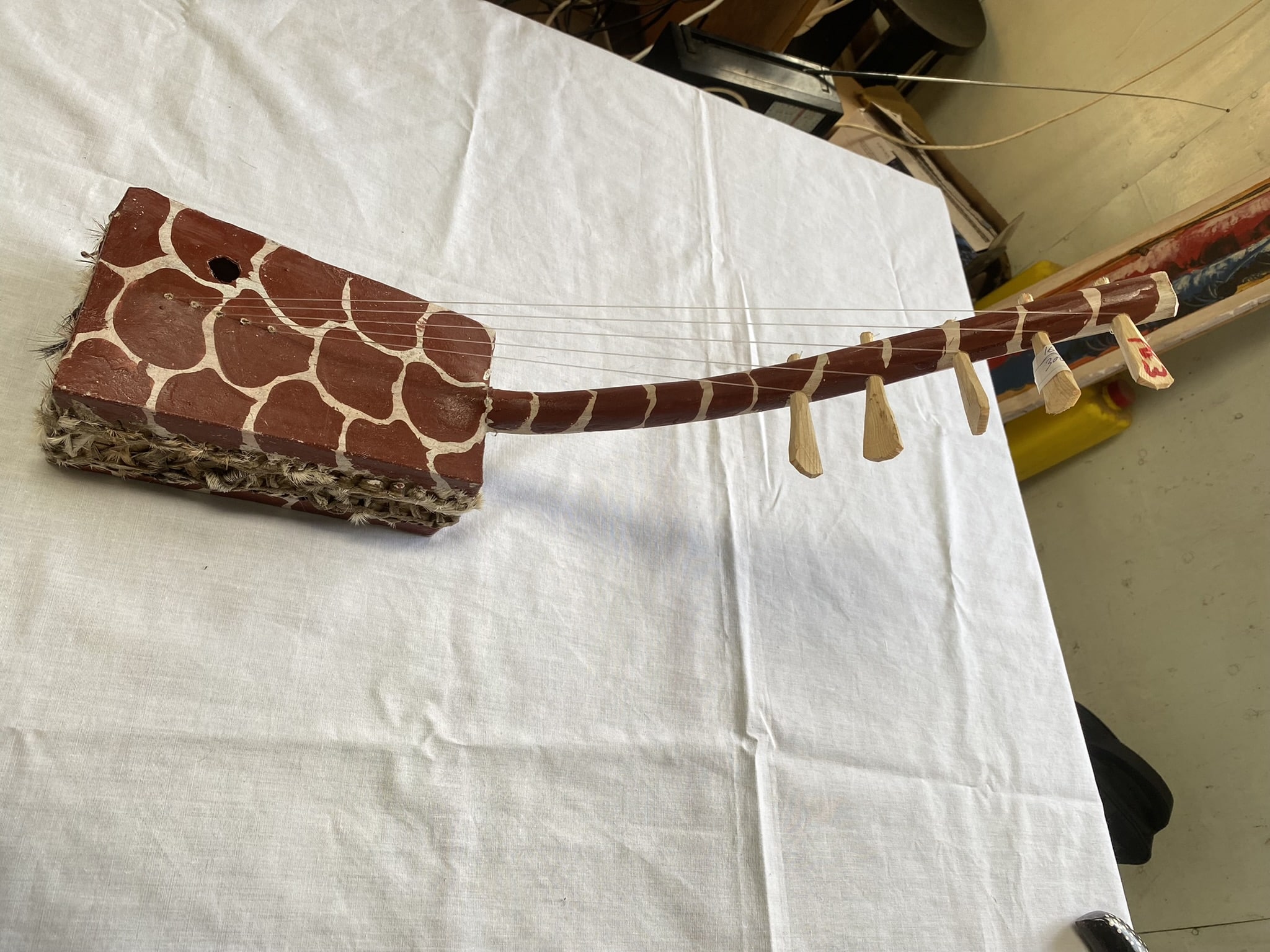 wooden 5 string musical instrument with giraffe pattern