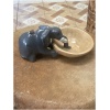 wooden gray elephant drinking from bowl