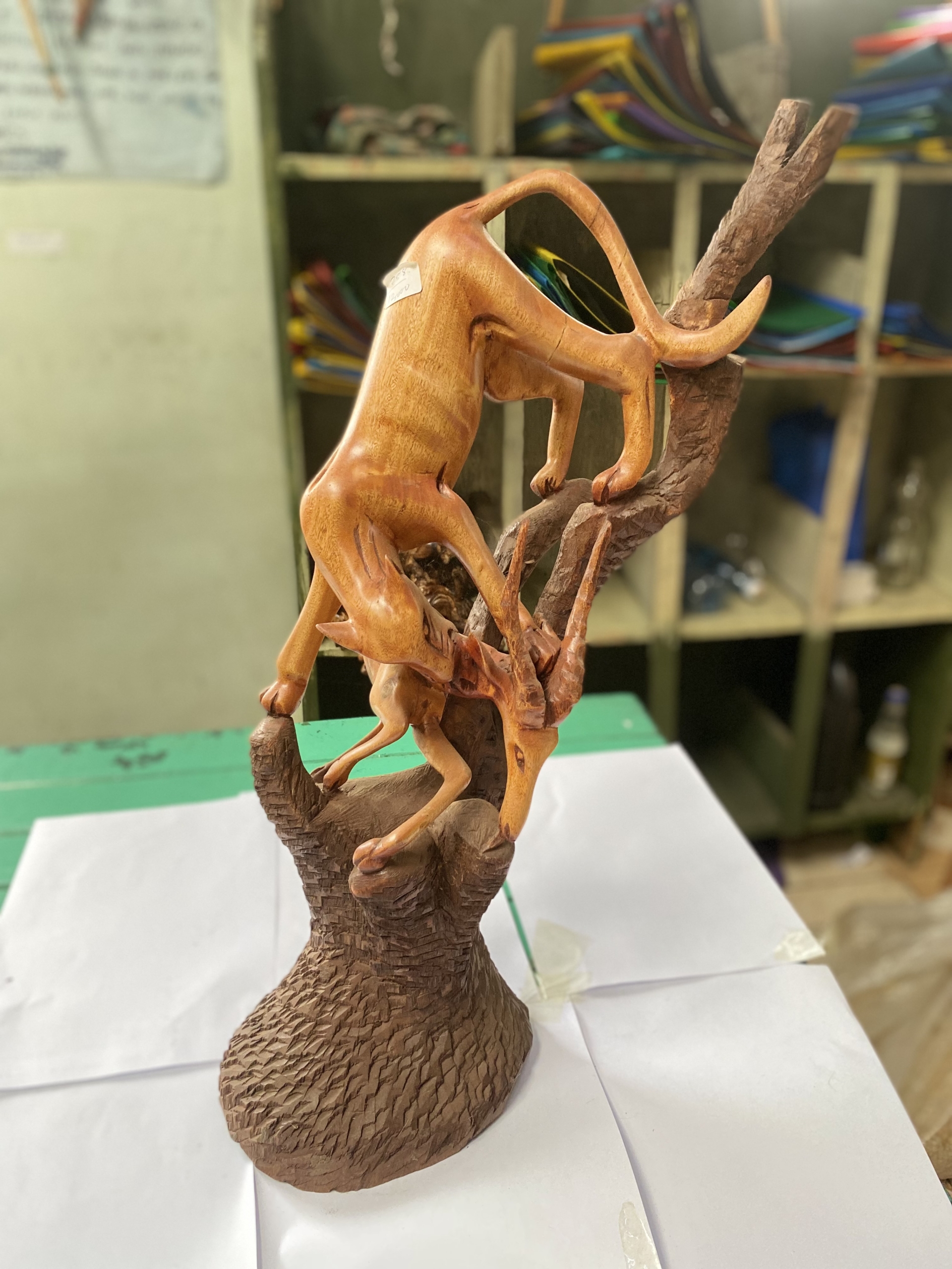 wooden leopard hunting gazelle on tree